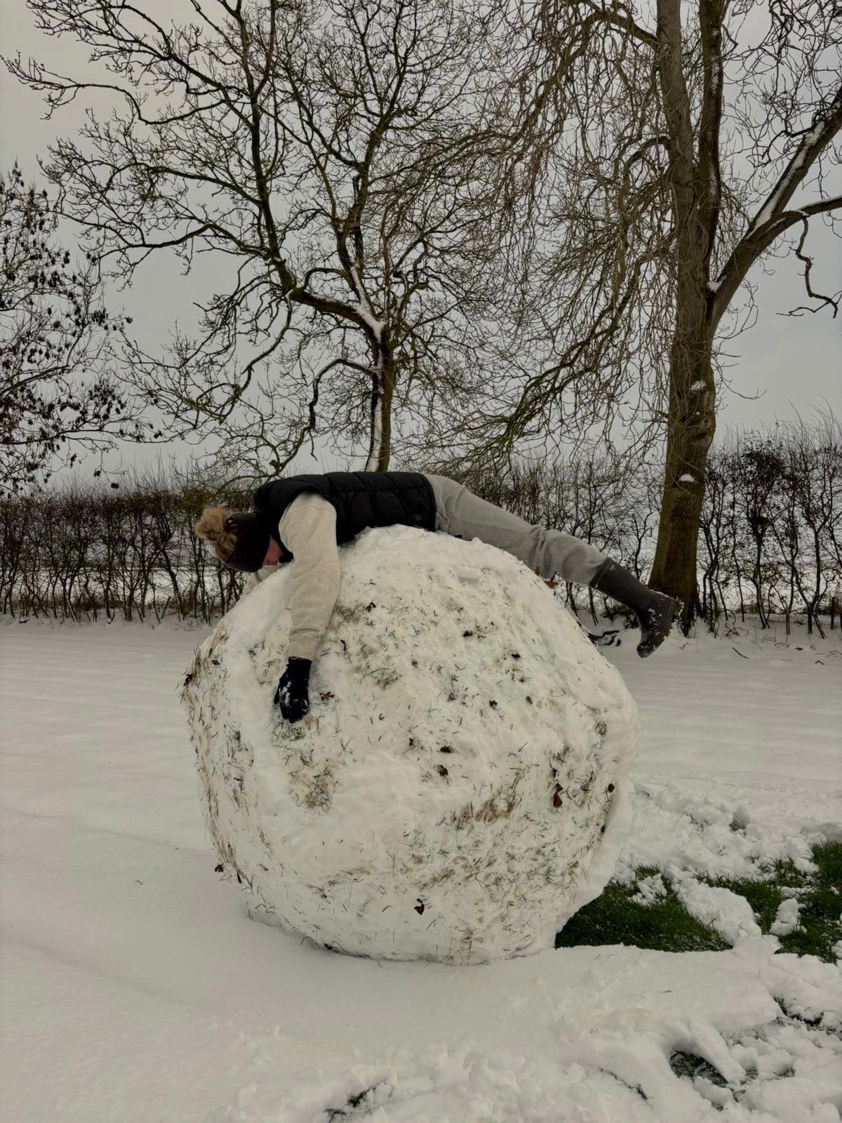 Georgia draped playfully over a giant snowball