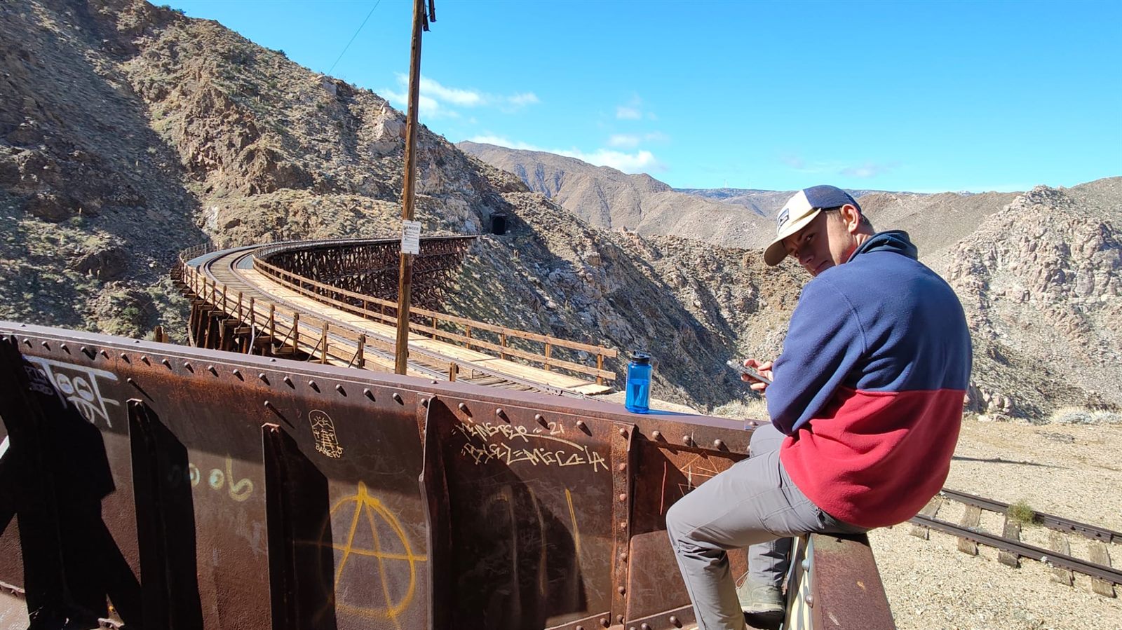 Will sitting beside a mountain railway bridge